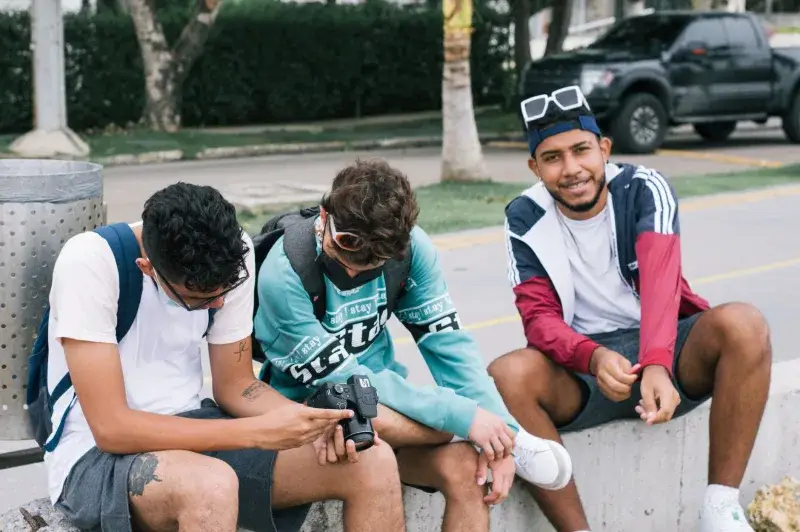 Three young men enjoying a casual hangout outdoors in Cartagena, Colombia.