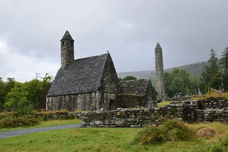 A serene view of the ancient St. Kevin's Church against an overcast sky in Glendalough, Ireland.