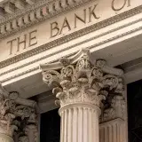 Una vista detallada de la fachada de un edificio bancario clásico con columnas corintias ornamentadas.