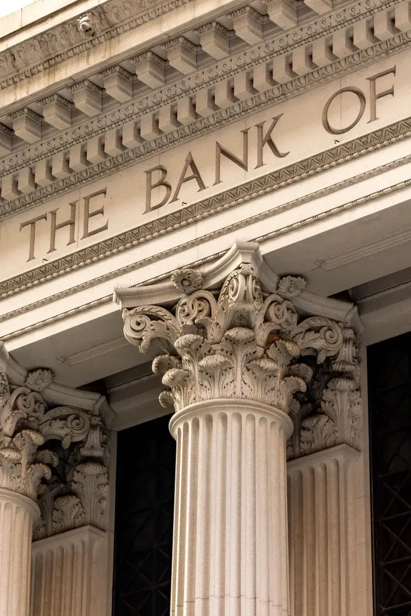 Una vista detallada de la fachada de un edificio bancario clásico con columnas corintias ornamentadas.