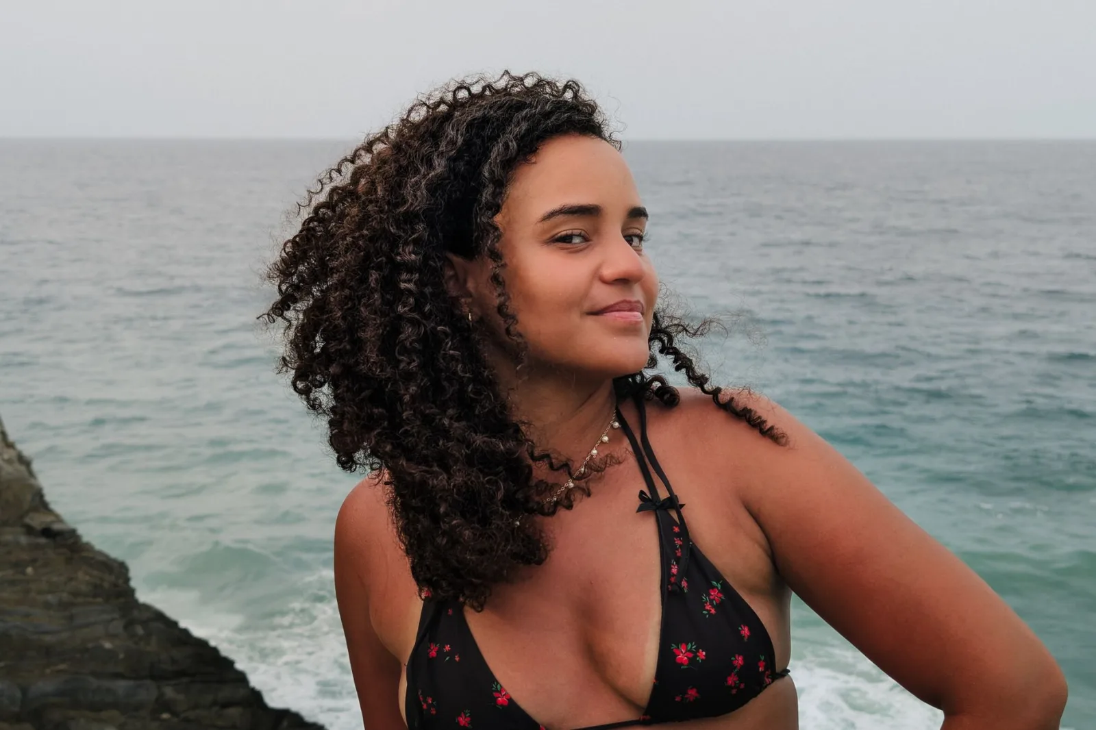 Woman smiling at the camera by the ocean in Cuyagua, Aragua, Venezuela, on a summer day.