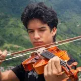 Portrait of a young violinist performing amidst the lush landscape of Mérida, Venezuela.