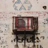 Weathered wall with air conditioner in Maracaibo, showcasing urban decay and street art.