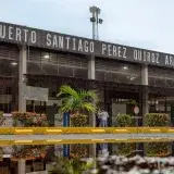 Exterior view of Santiago Perez Quiroz Airport in Arauca, Colombia, with reflection in a puddle.