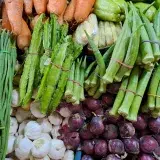 A vibrant assortment of fresh vegetables including carrots, okra, and garlic at a market in Valenzuela, Philippines.