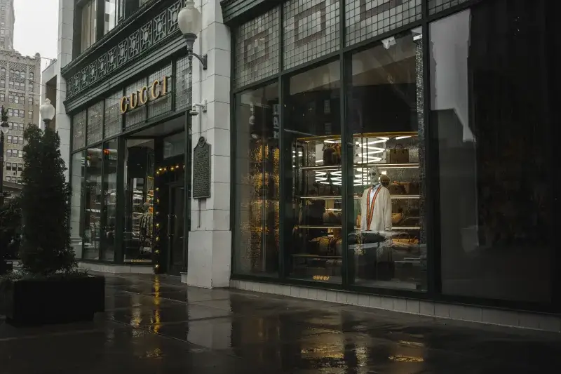 Stylish Gucci storefront in Detroit reflecting urban elegance on a rainy day.