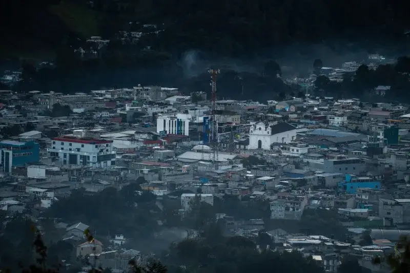 A stunning aerial view of Santa Cruz del Quiché, capturing its urban sprawl and surrounding landscape at dusk.