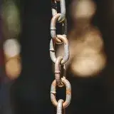 Detailed close-up of a hanging rusty metal chain outdoors in Mérida, Venezuela.
