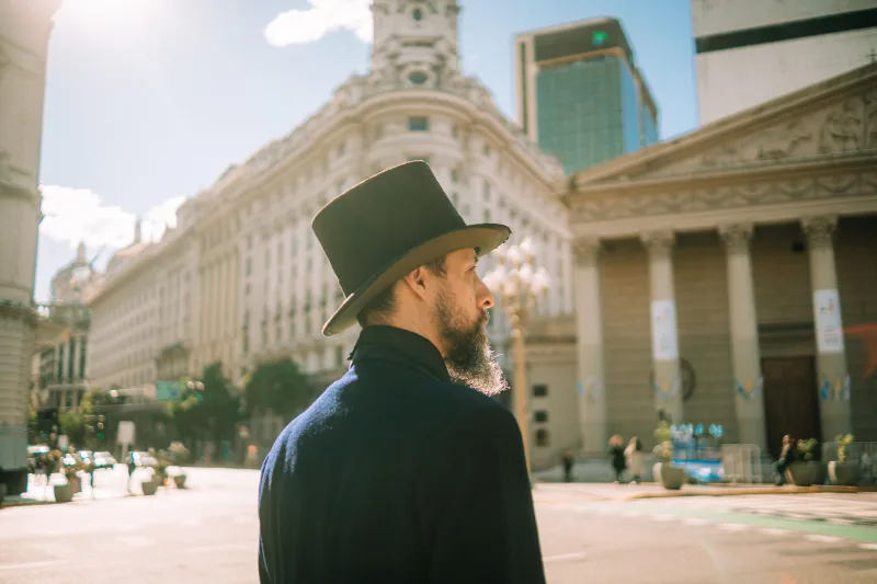 A man with a hat and beard exploring the streets of Buenos Aires, Argentina, on a sunny day.