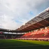 Wide-angle shot of Geneva's SFC stadium with empty seats and sky highlights.