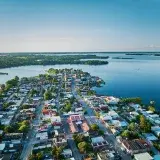Stunning aerial view of the vibrant town of Catazajá, Chiapas, Mexico by a serene lake under a clear blue sky.