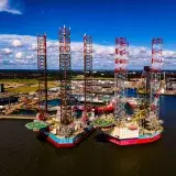 Stunning aerial view of oil rigs docked at the port of Esbjerg in Denmark. Clear day with vibrant colors.