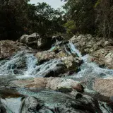 Scenic waterfall cascading over rocks in a lush forest in Victoria, Caldas, Colombia.