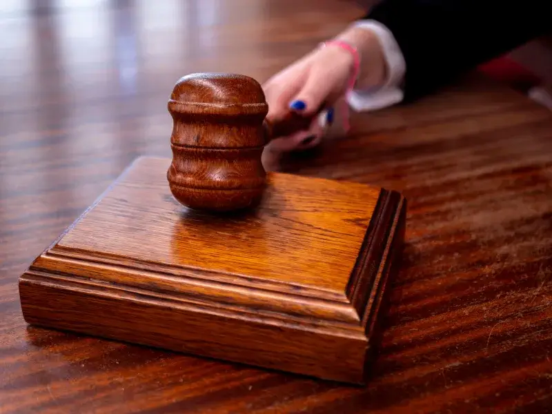 Close-up of a wooden judge's gavel on a desk in a courtroom, symbolizing justice.