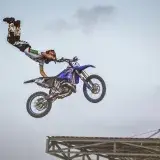 Motorcyclist performs an aerial trick on a blue bike in Rabat, Morocco.