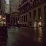 Dimly lit evening street scene in New York City, showcasing architecture and urban life.