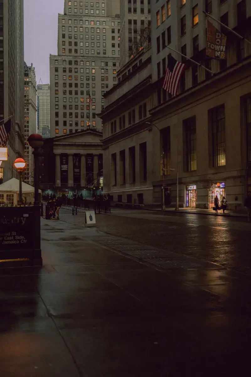 Dimly lit evening street scene in New York City, showcasing architecture and urban life.