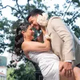 Happy couple embraces outdoors in Venezuela in elegant bridal attire.