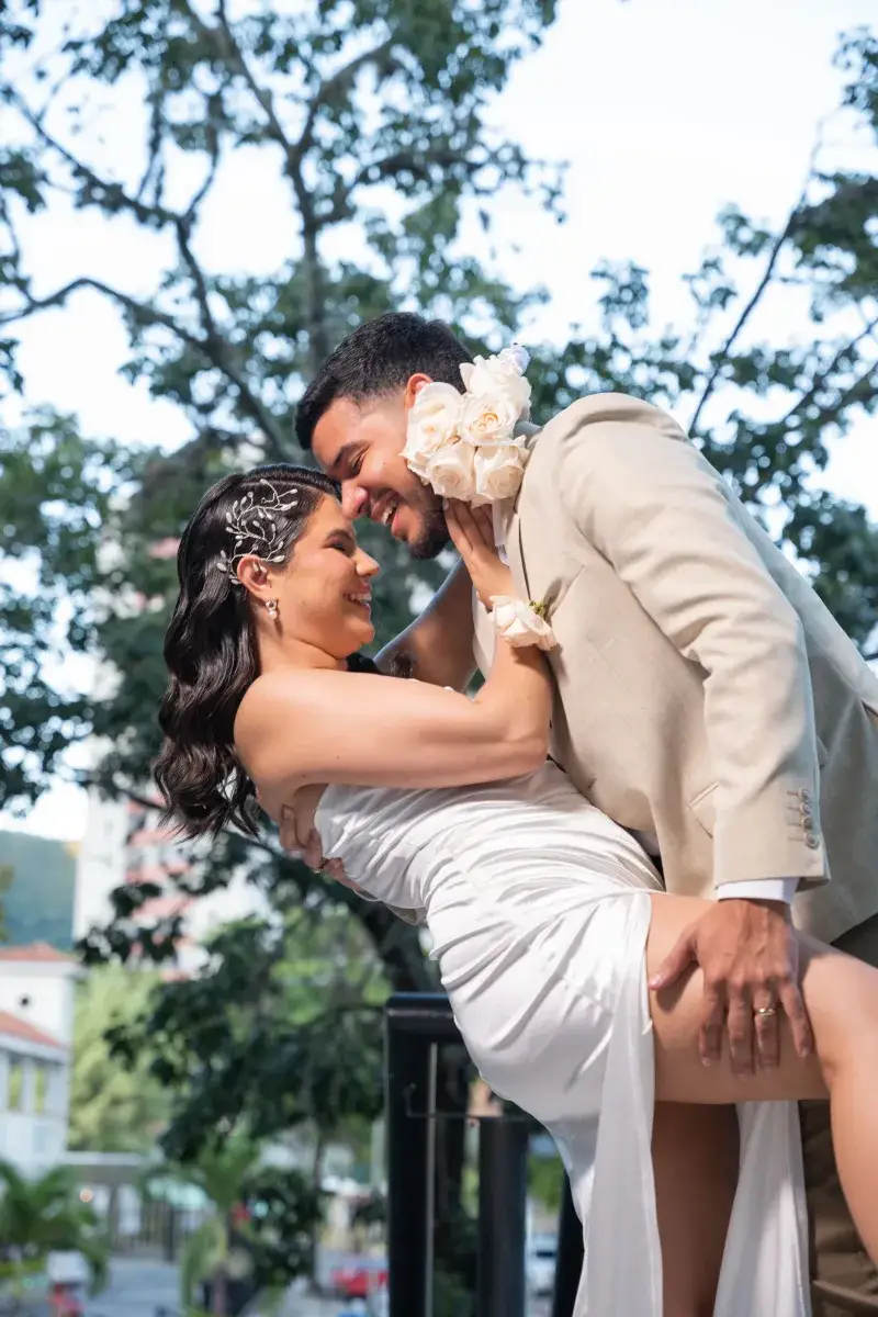 Happy couple embraces outdoors in Venezuela in elegant bridal attire.