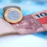 A coin sitting on top of a pile of money