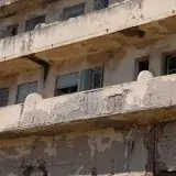 Dilapidated balconies of a weathered building are shown.
