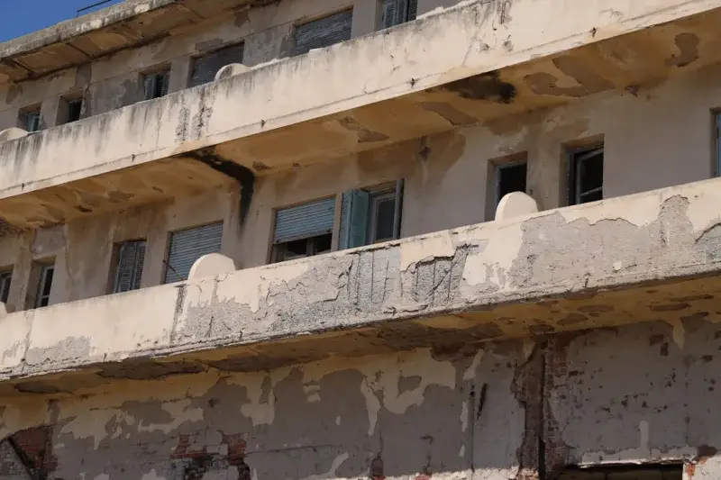 Dilapidated balconies of a weathered building are shown.