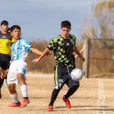 Two young soccer players competing fiercely on the field during a match.