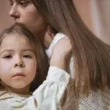 Tender moment between a mother and child embracing indoors, capturing love and connection.