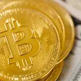 Detailed macro shot of stacked bitcoins on a US dollar bill, symbolizing digital and traditional currency convergence.