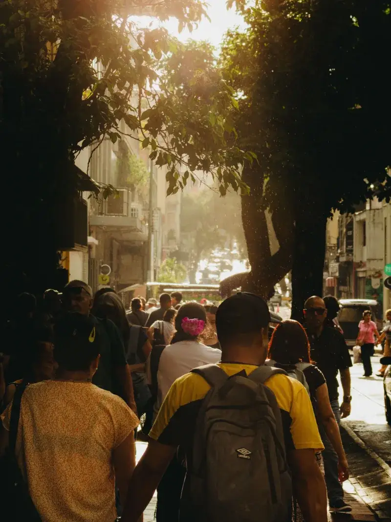 A lively street in Caracas, Venezuela, illuminated by the warm glow of sunset.