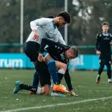 Intense soccer match capturing two players in a tackle on a lush green field.