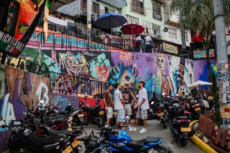 Dynamic street scene featuring colorful graffiti and local culture in Medellín, Colombia.