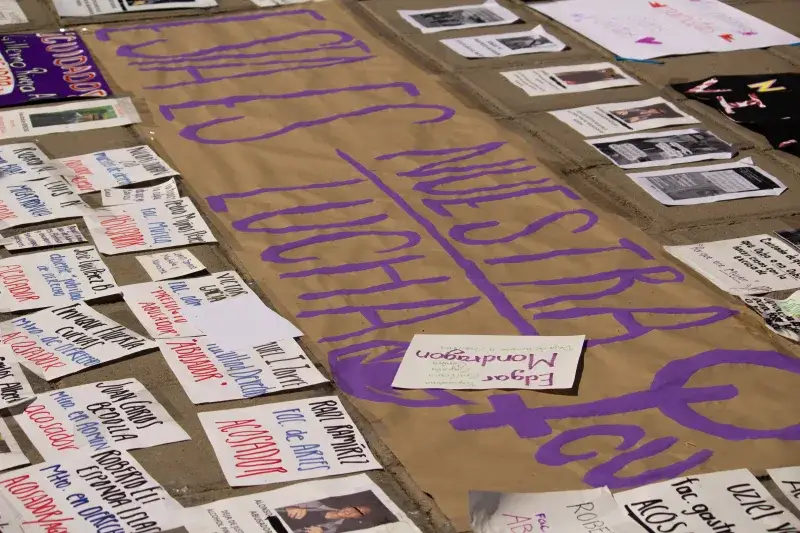 Protest signs laid on the pavement, highlighting messages of unity and social justice.