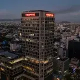 Aerial view of the MAPFRE Tower in Mexico City at twilight. Vibrant cityscape under the evening glow.