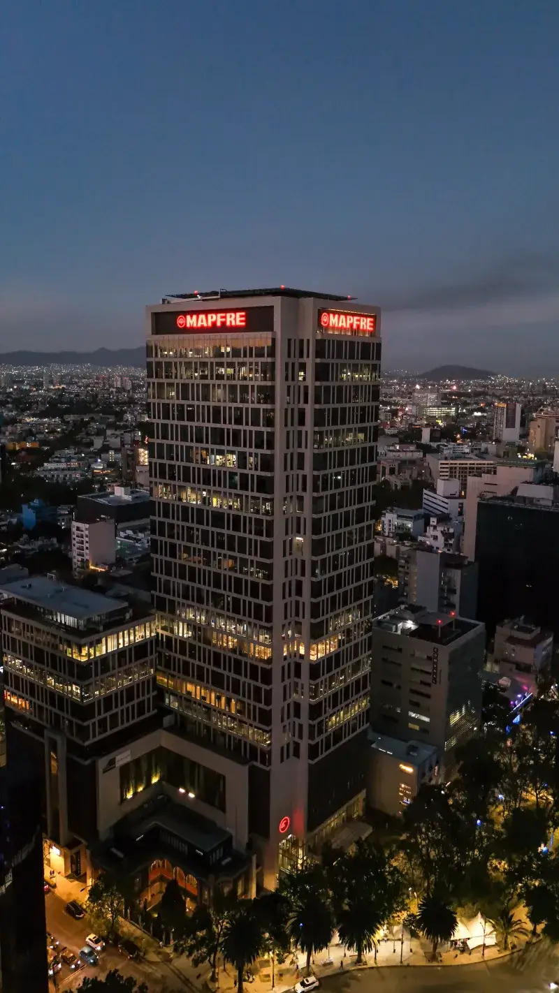 Aerial view of the MAPFRE Tower in Mexico City at twilight. Vibrant cityscape under the evening glow.
