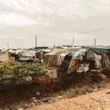 Expansive view of provisional shelters in a refugee camp, highlighting the struggle and resilience.