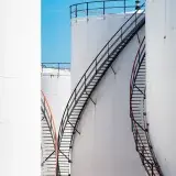 Vertical shot of large steel oil storage tanks with stairs in Antwerp, Belgium.