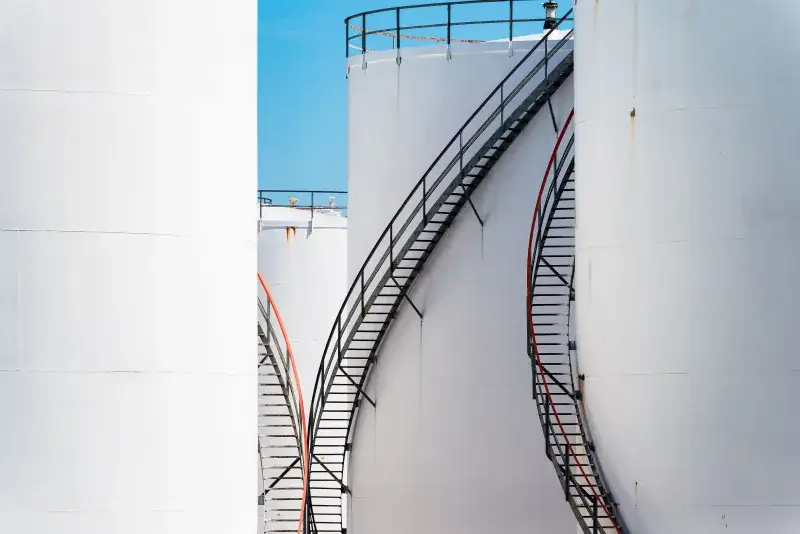 Vertical shot of large steel oil storage tanks with stairs in Antwerp, Belgium.