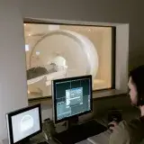 Health worker examines MRI scan data in a clinical setting.