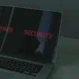 Close-up of a laptop displaying cybersecurity text, emphasizing digital security themes.