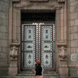 Elegant and historic ornate door in Mérida, Venezuela with pedestrians passing by.