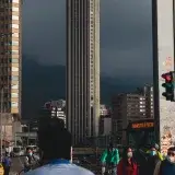 City scene in Bogotá, Colombia showcasing a busy street with pedestrians and a prominent skyscraper.