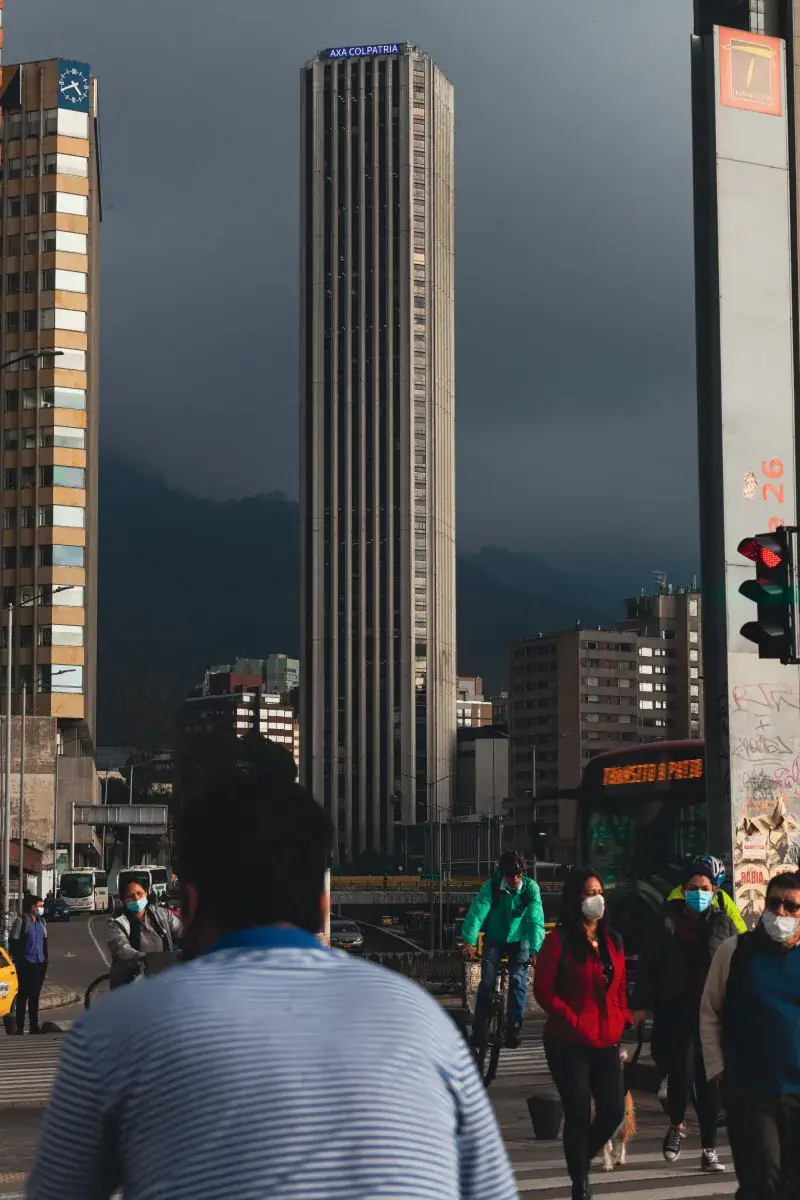 City scene in Bogotá, Colombia showcasing a busy street with pedestrians and a prominent skyscraper.