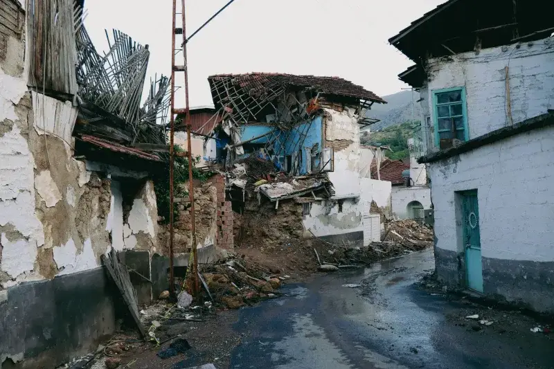 A devastated urban street in Malatya, Turkey after an earthquake, showcasing collapsed traditional houses.