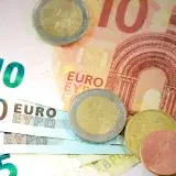 Detailed shot of Euro banknotes and coins showcasing currency denominations.