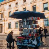 A vibrant street vendor booth in Bogotá selling various phone accessories under a large umbrella.
