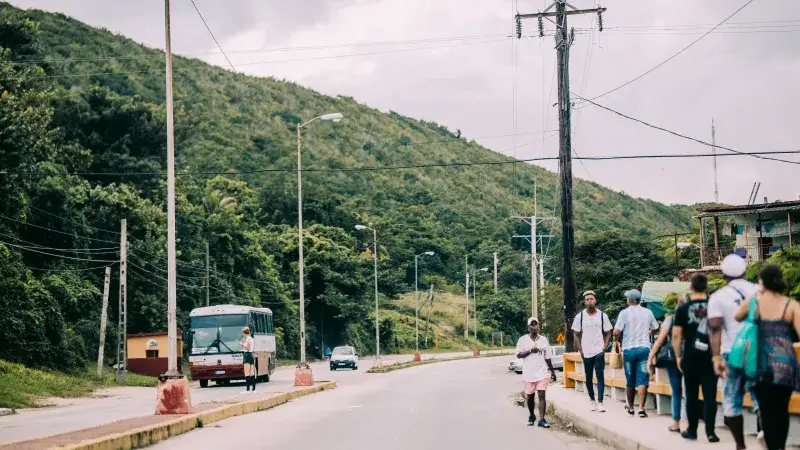 Street scene in Santa Cruz del Norte, Cuba with people and vehicles on a sunny day
