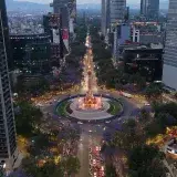 Stunning aerial shot of Paseo de la Reforma in Mexico City with jacaranda trees and city lights.