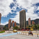Explore the bustling streets of Bogotá, Colombia, featuring skyscrapers, TransMilenio bus, and lively urban scenery.