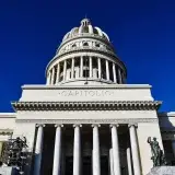 Low angle view of the iconic El Capitolio building under a clear blue sky in Havana, Cuba.